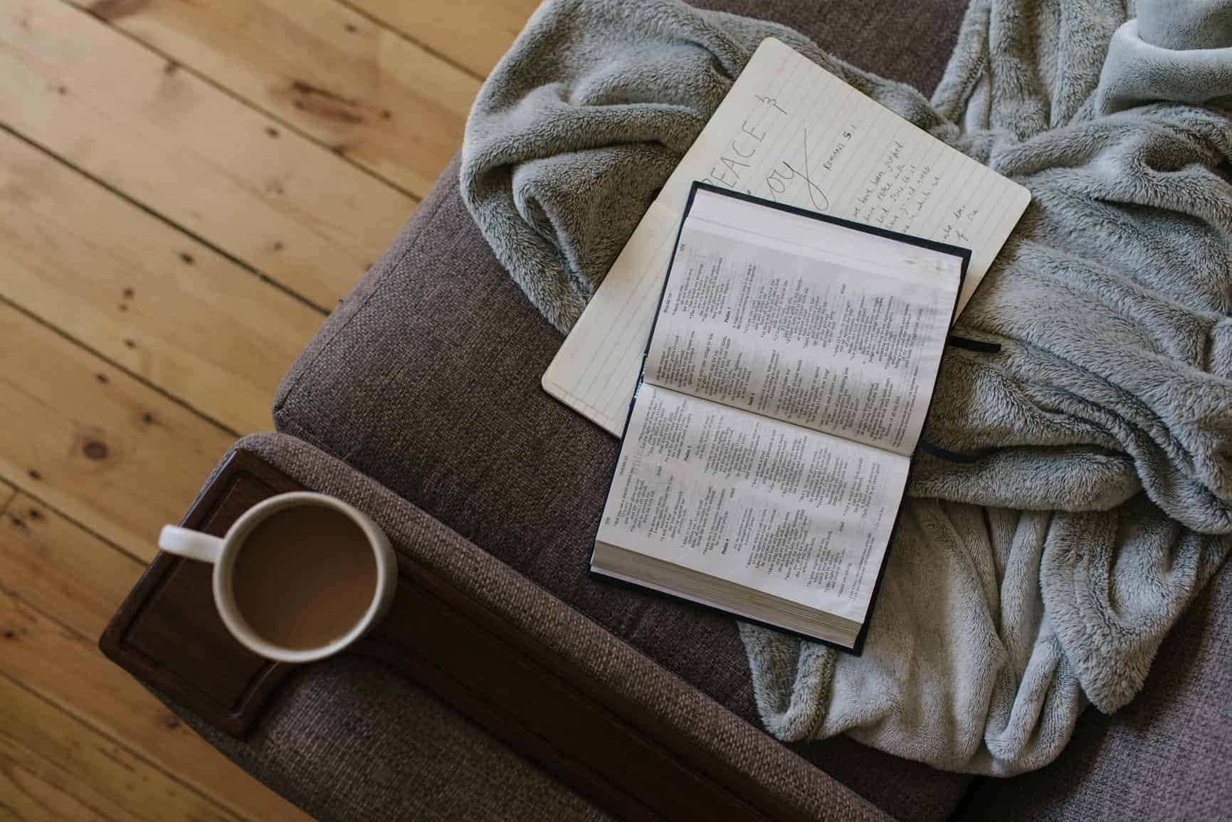A Bible and some coffee laid out on a couch